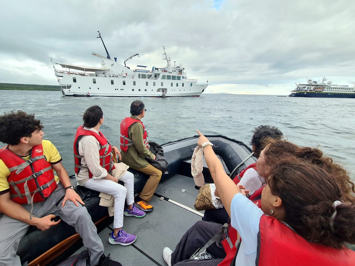 Inselhopping-Gäste mit Kreuzfahrtschiff im Hintergrund